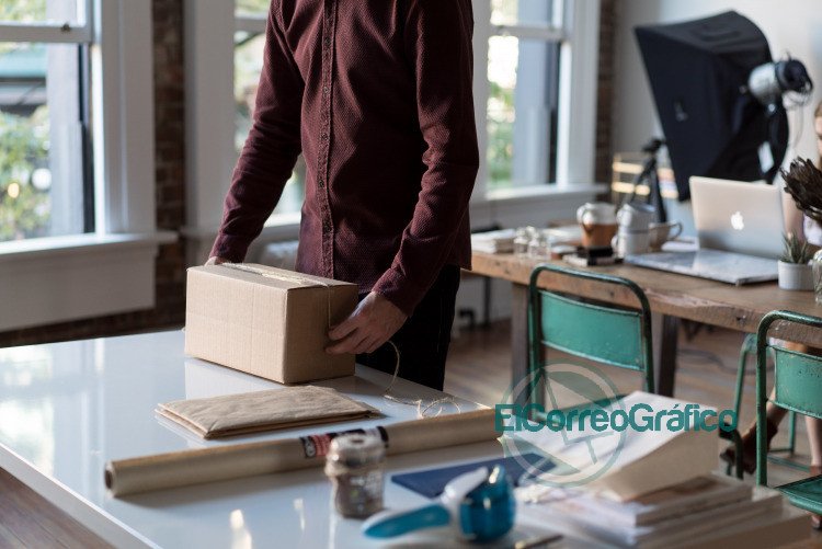 person holding cardboard box on table