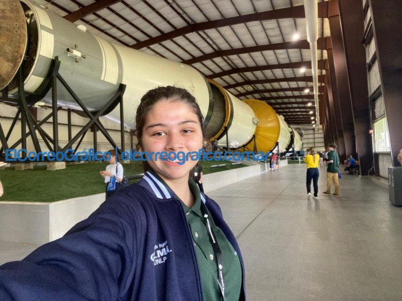 Alumna de la Facultad de Ingeniería en la NASA: proyectó una misión tripulada a Marte La estudiante de Ingenieria en el George W.S. Abbey Rocket Park. En el fondo se observa el modelo del Saturn V un cohete que se utilizaba en las misiones Apolo