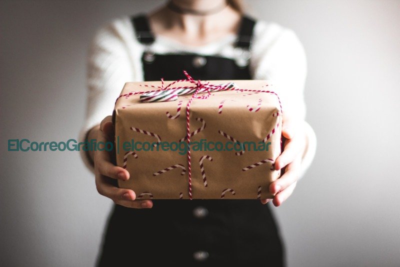 enviar paquete persona mostrando caja de regalo marrón