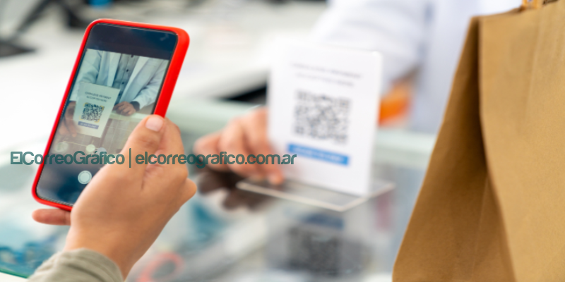 ¿El fin del efectivo? Los medios de pago digitales ganan terreno entre los consumidores Una persona con el celular en la mano lee un código QR de una tarjeta para realizar un pago digital