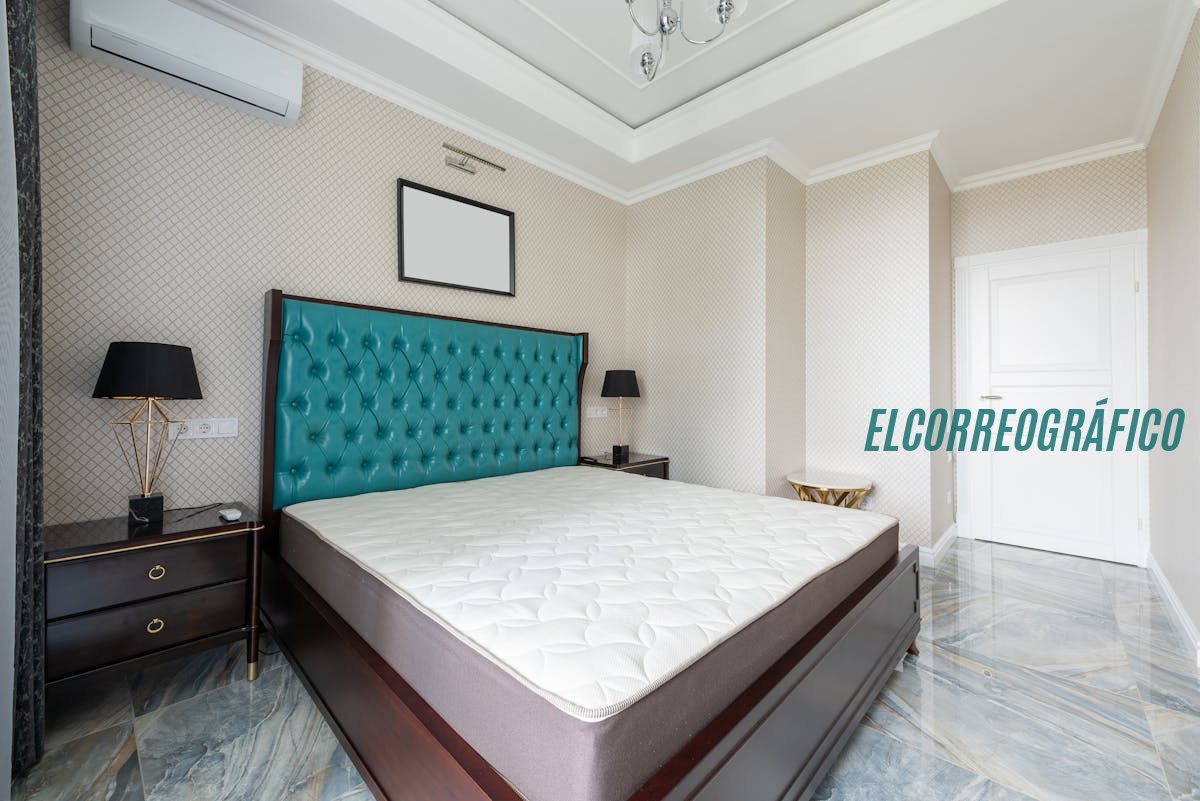 Dormitorio moderno con un diseño elegante, cabecero de terciopelo en color teal y suelo de mármol.Guía Experta: Cómo Elegir el Colchón Perfecto en 2026 y Mejorar Tu Salud